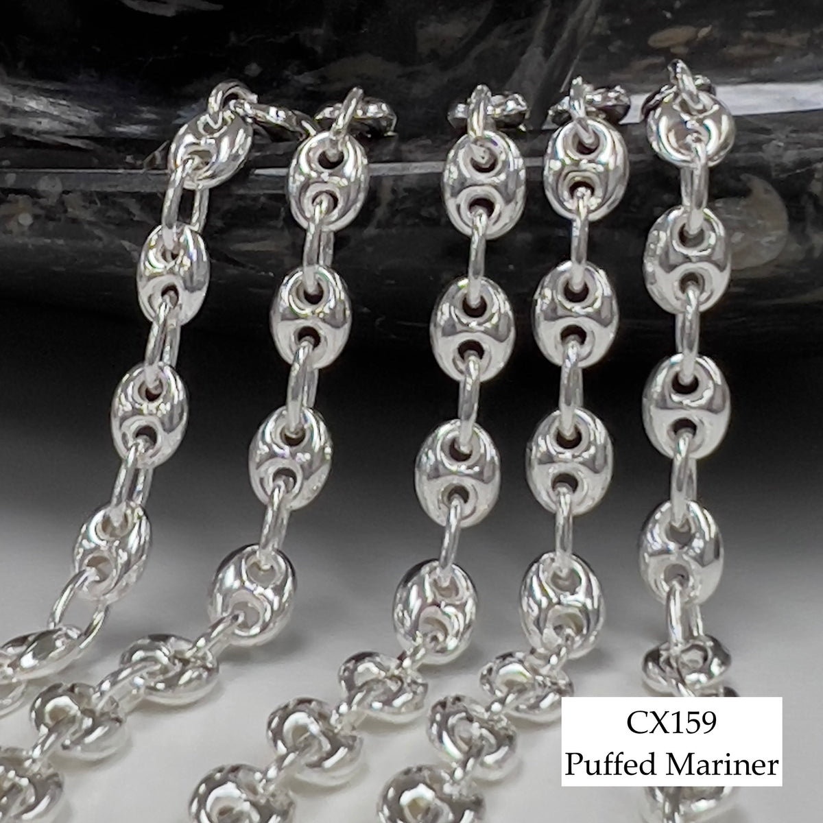 Silver chain with 'CX159 Puffed Mariner' label on a reflective surface