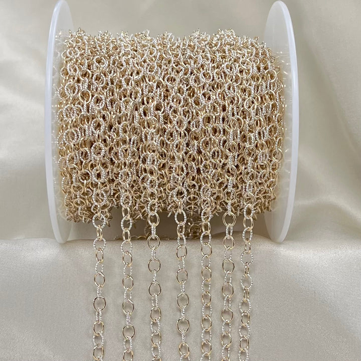 Spool of silver and gold chain on a white background