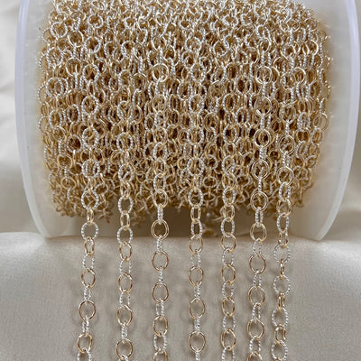Spool of gold and white cable chain on a white background