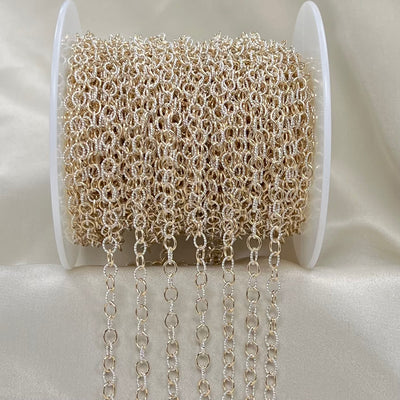 Spool of silver and gold chain on a white background