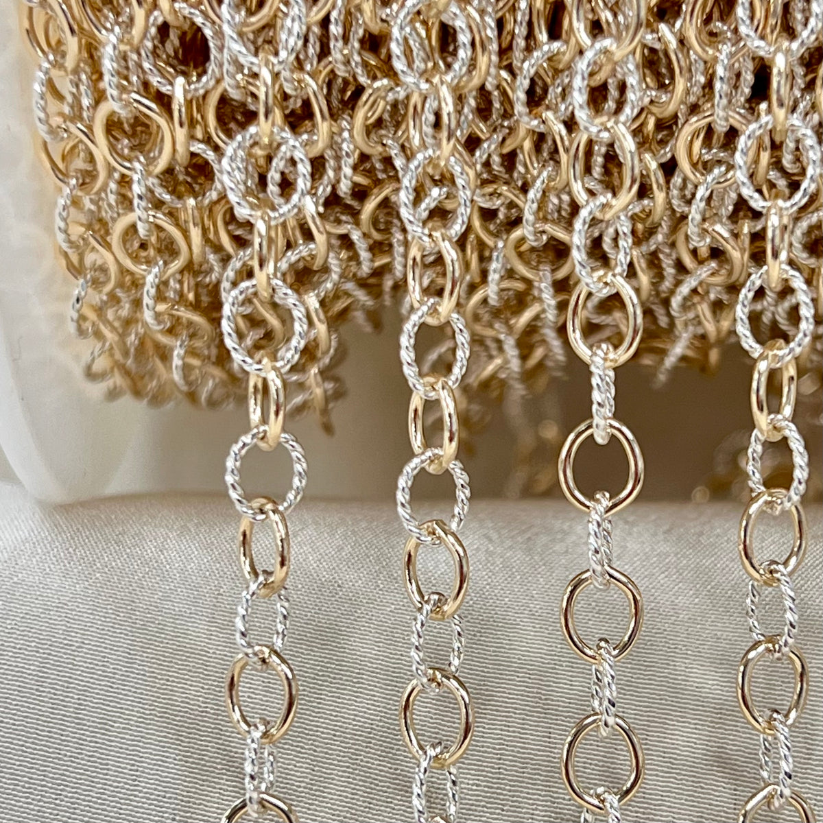 Close-up of gold and silver chain on a neutral background