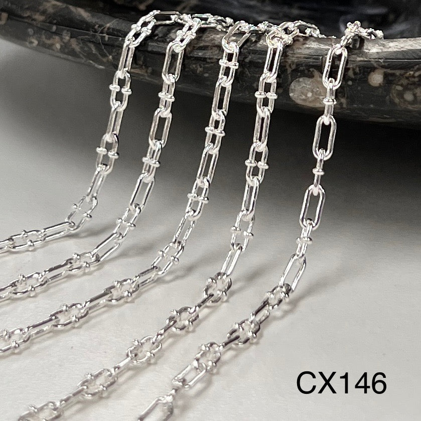 Silver chain on a textured surface with 'CX146' label
