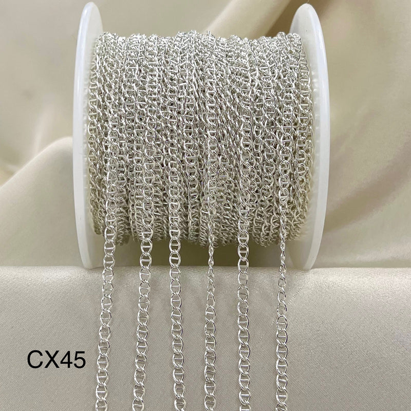 Spool of silver chain on a beige background
