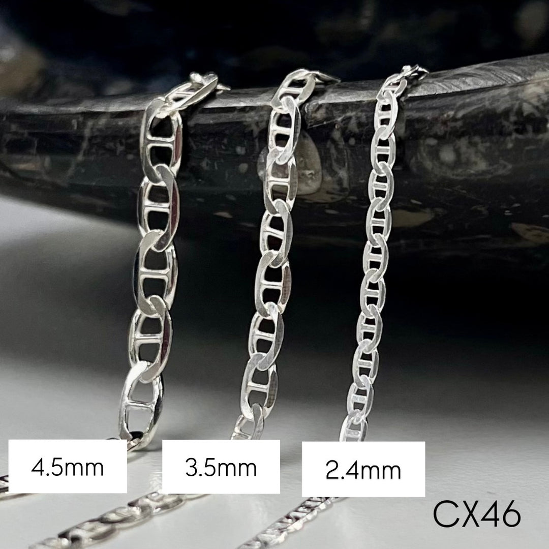 Three silver mariner chain necklaces of different widths on a dark background