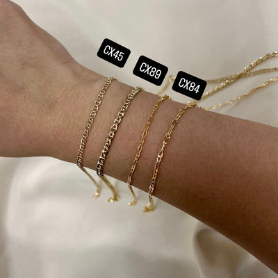 Three Mariner gold filled chain bracelets on a wrist with labels CX45, CX89, and CX84 against a neutral background.