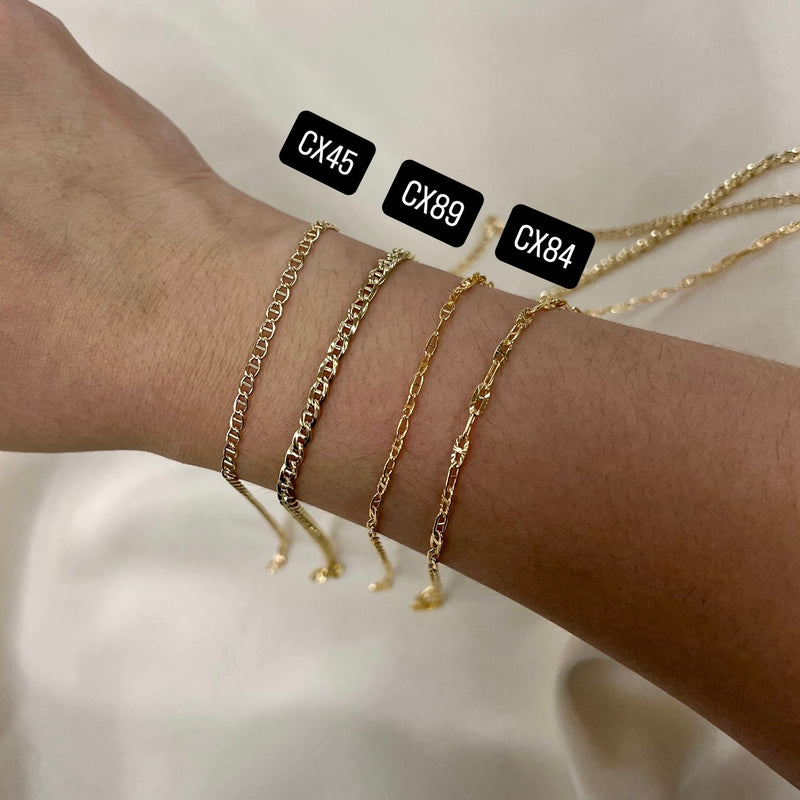 Three Mariner gold filled chain bracelets on a wrist with labels CX45, CX89, and CX84 against a neutral background.